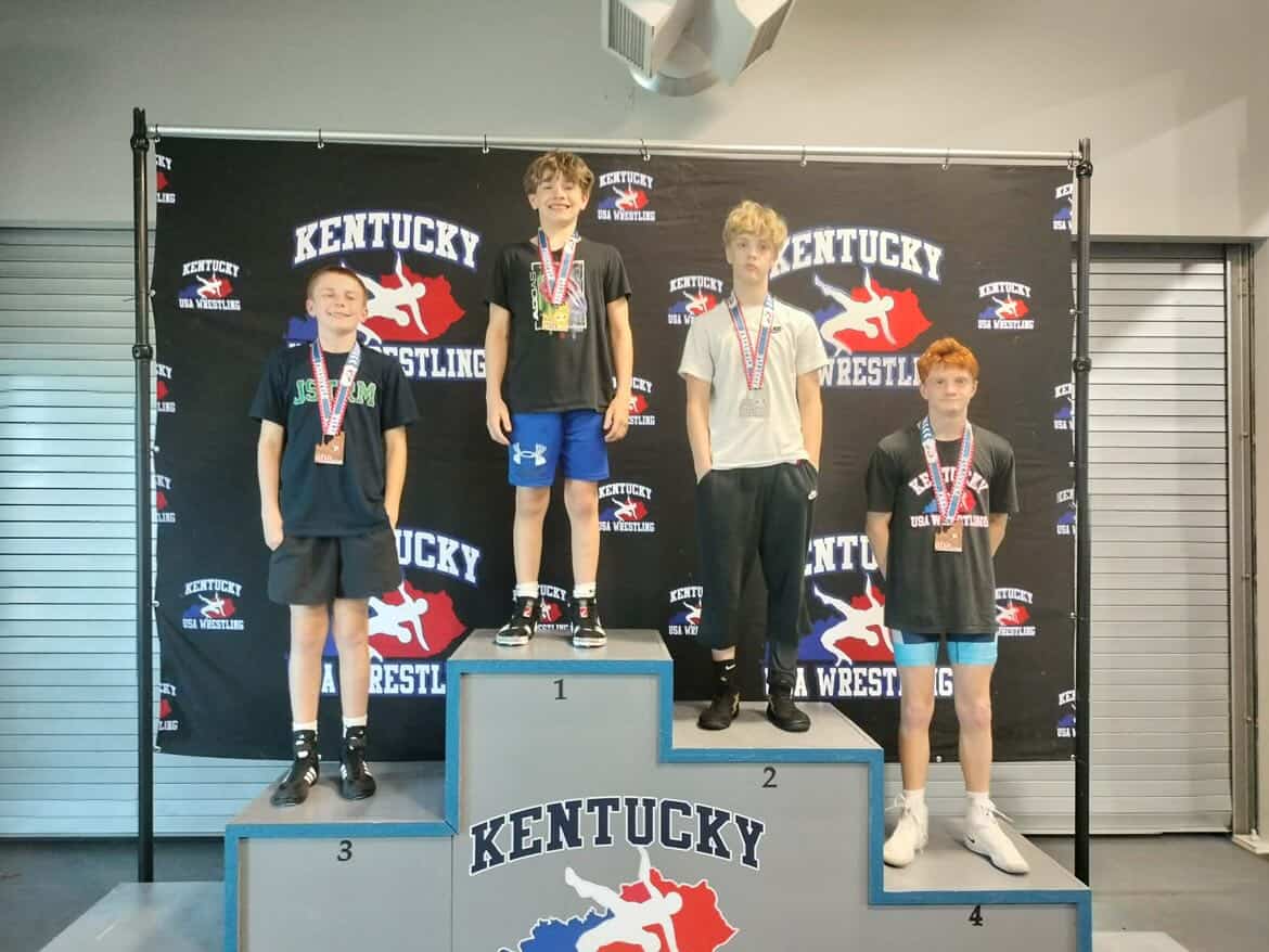 Young wrestlers standing on the podium with their medals